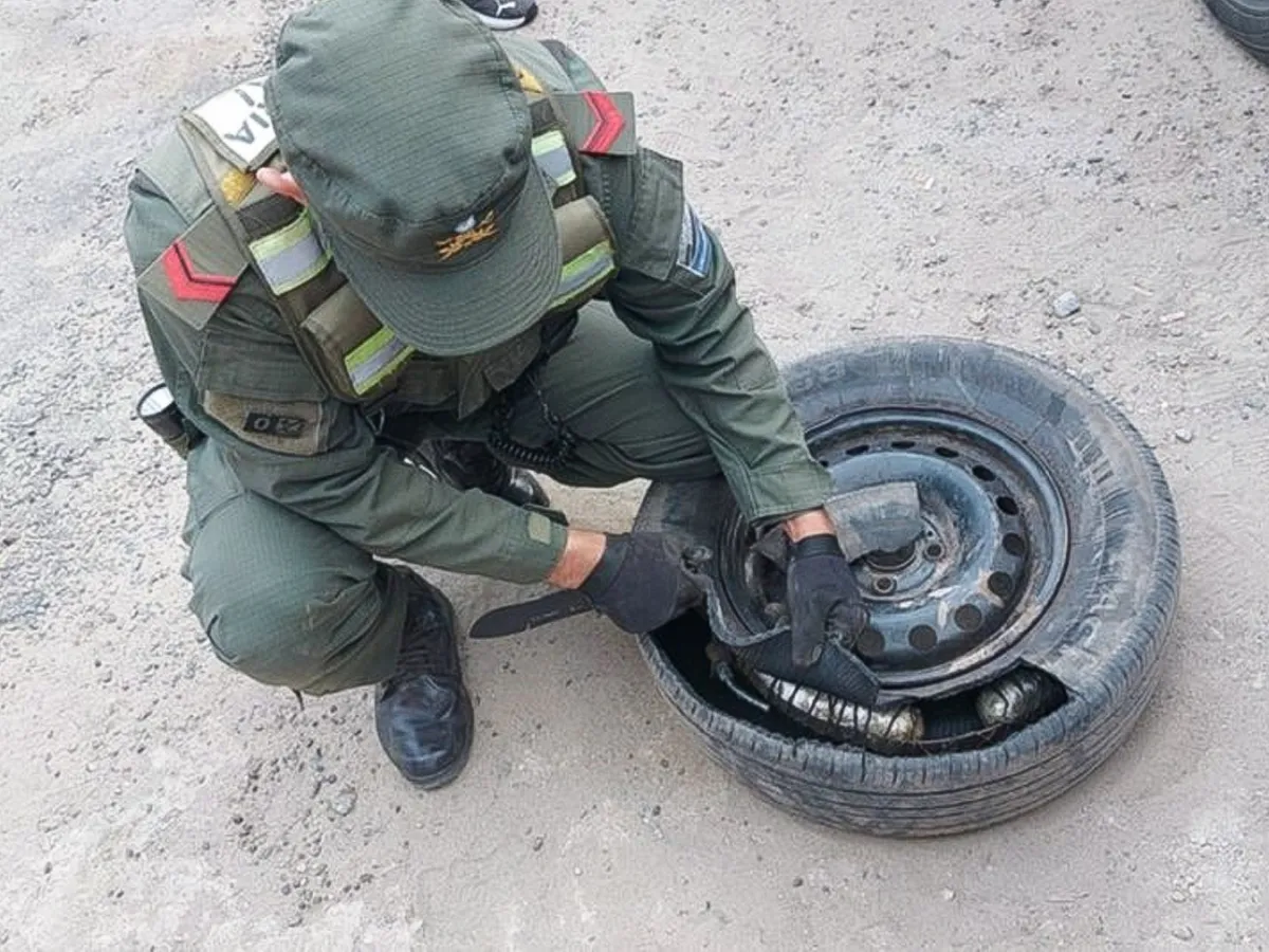Gendarme abre el neumático del auto remolcado.